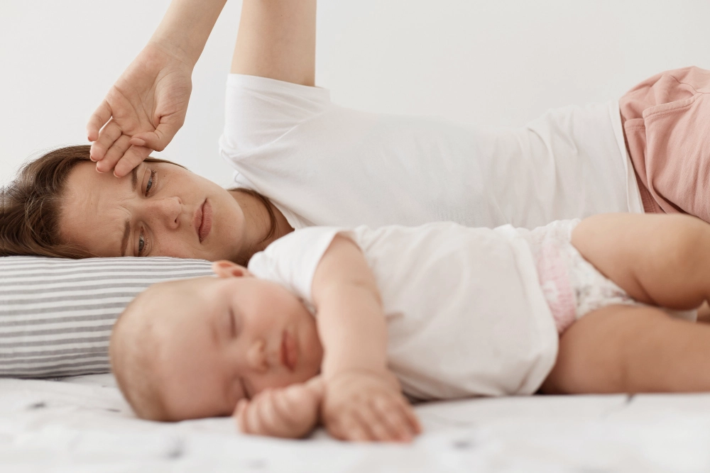 Mamá cansada después de dormir a su bebé.